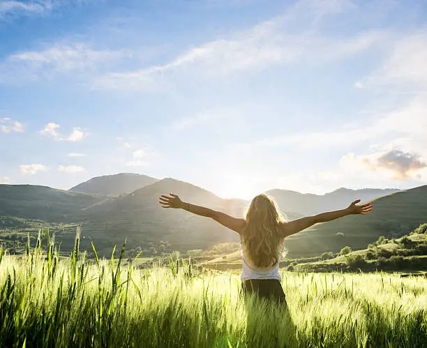 Woman in nature with arms stretched out