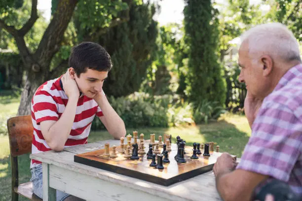 Grandfather and grandson playing chess together