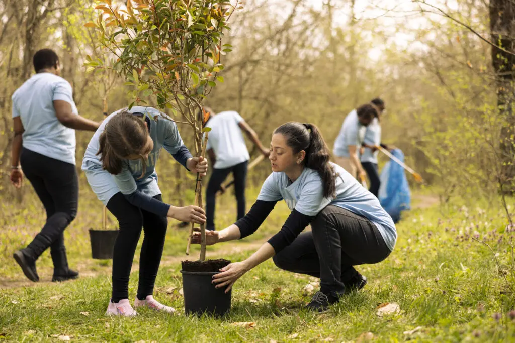 Mother and daughter preparing to plant a tree in the woods